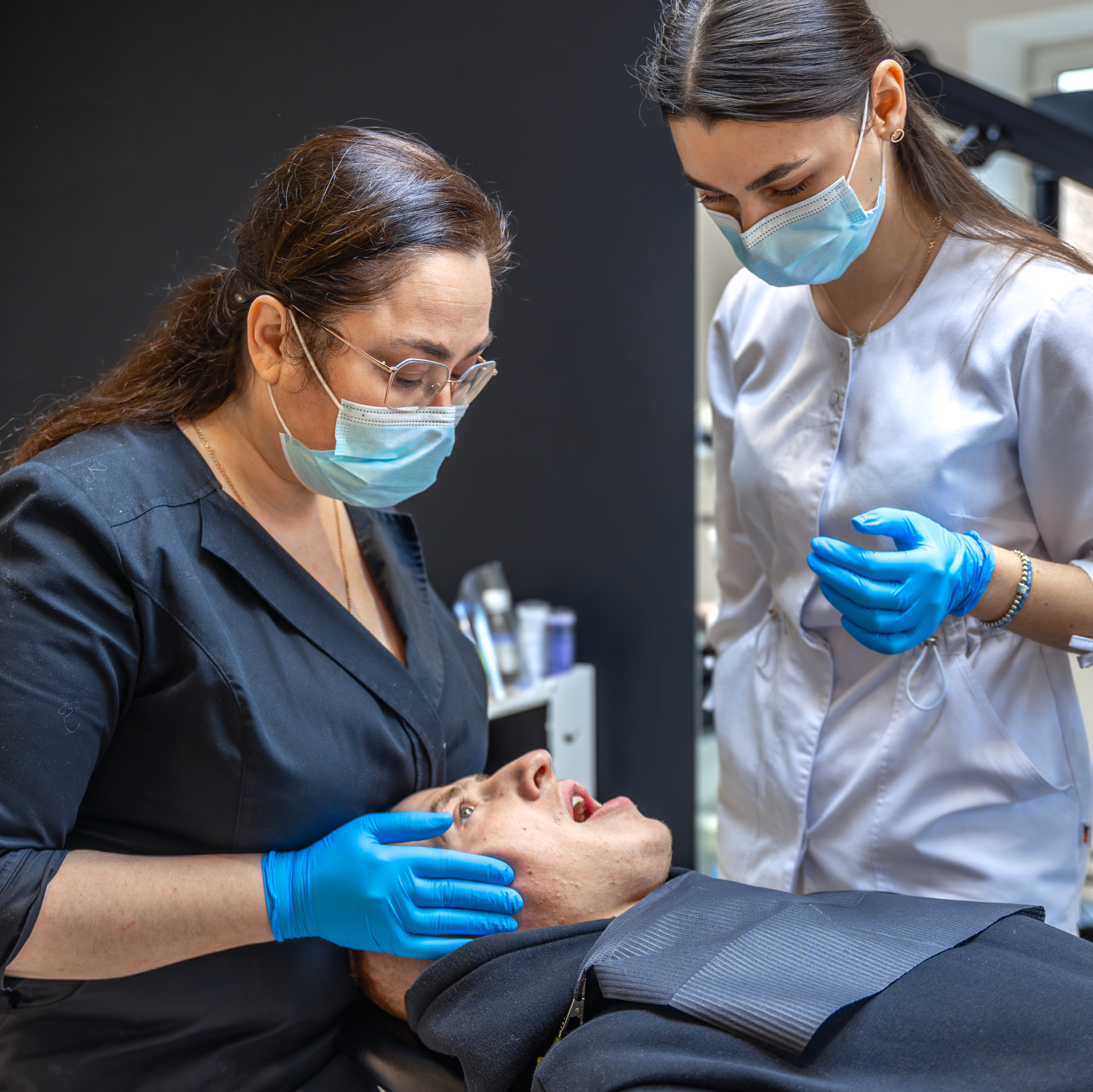 Student in dental office training with their instructor on a patient.